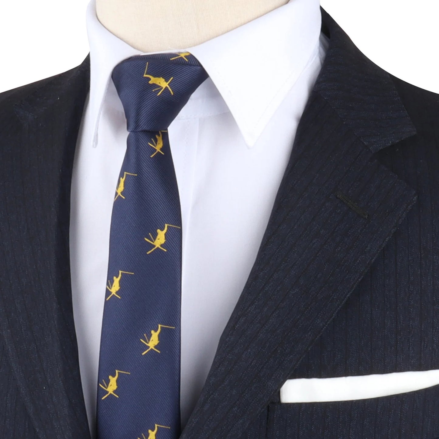 Close-up of a person in a black pinstripe suit and white dress shirt, wearing a navy tie with a yellow airplane pattern that evokes the elegance of Ski Tie. A white pocket square peeks from the suit's breast pocket.