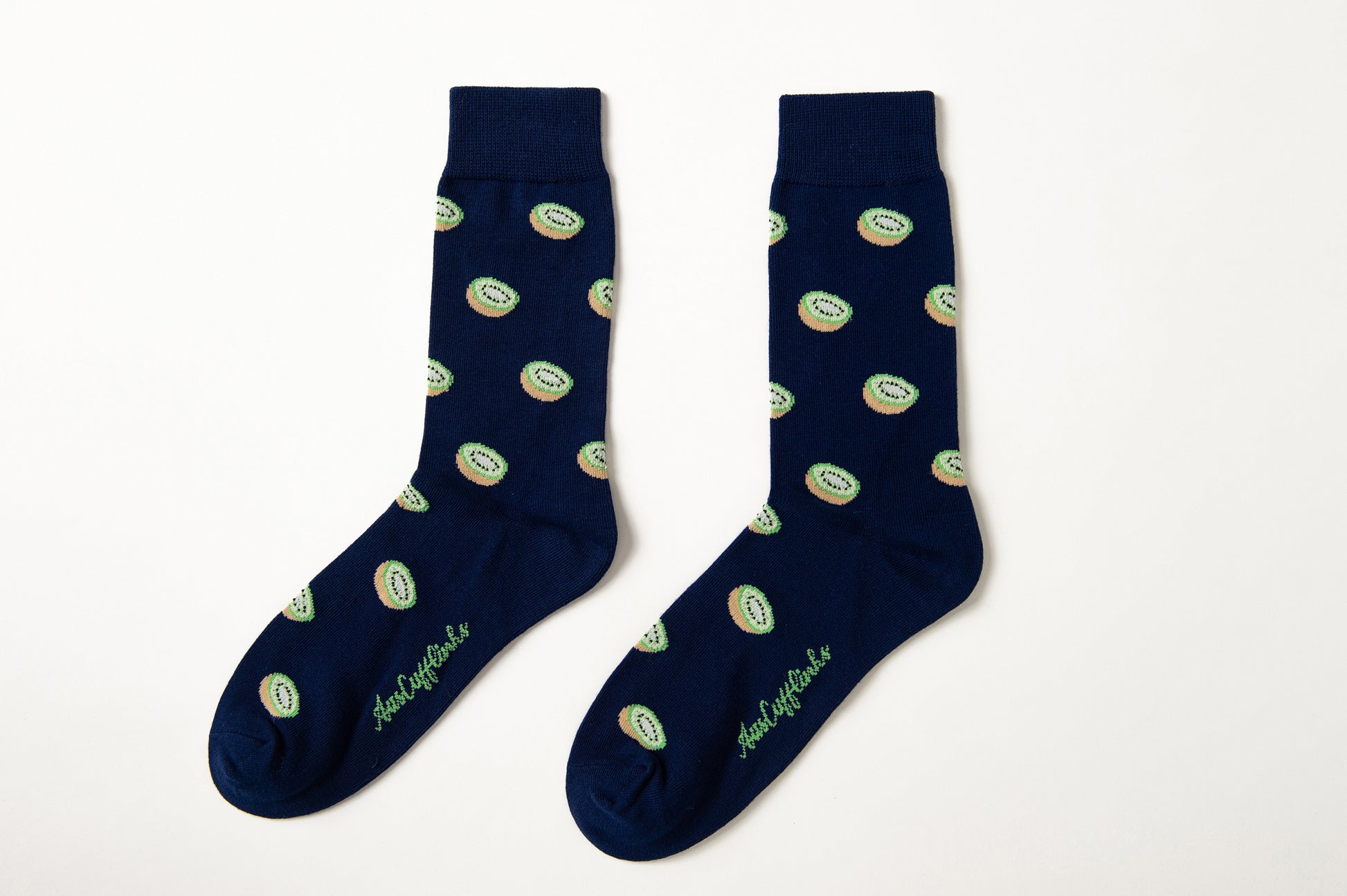 Kiwi Socks: Navy blue tropical socks featuring a repeating green kiwi fruit pattern and cursive text near the toes, shown on a white background.