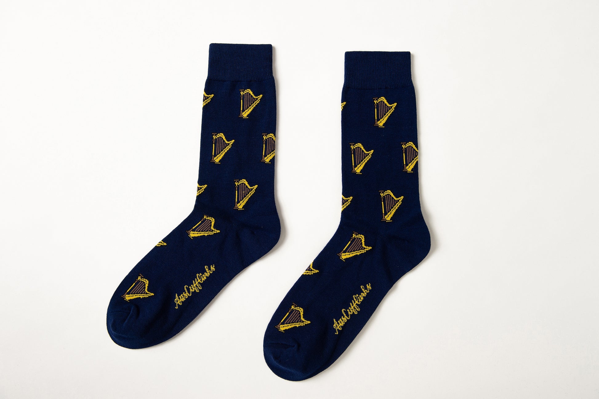 Harp Socks in navy blue with a yellow and black harp pattern and gold cursive text near the toes, shown on a white background—perfect for classical music lovers.