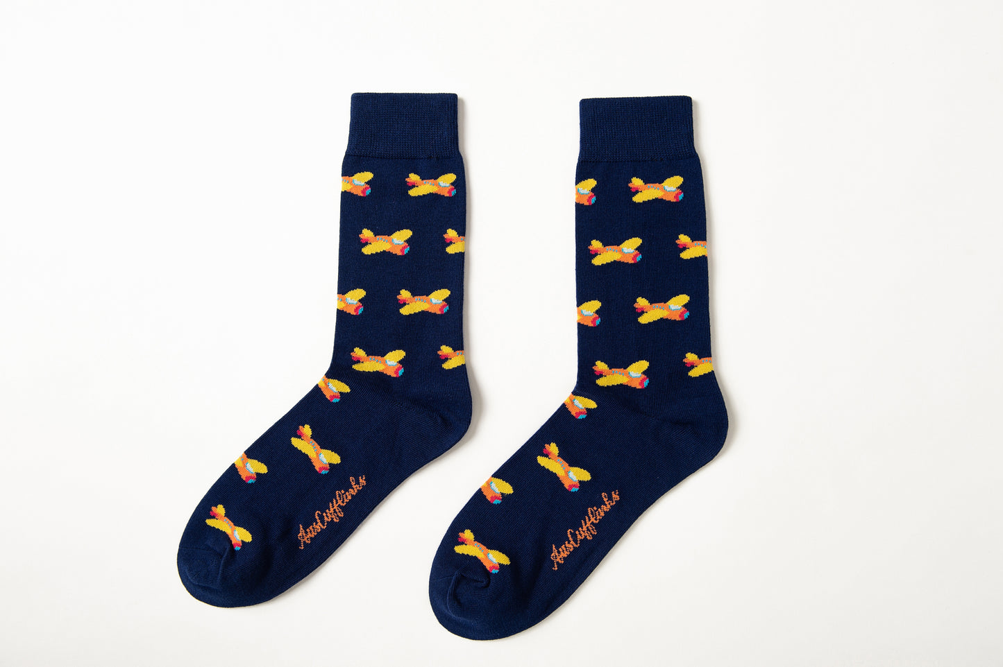 Fun novelty socks for men featuring orange airplane design on navy background