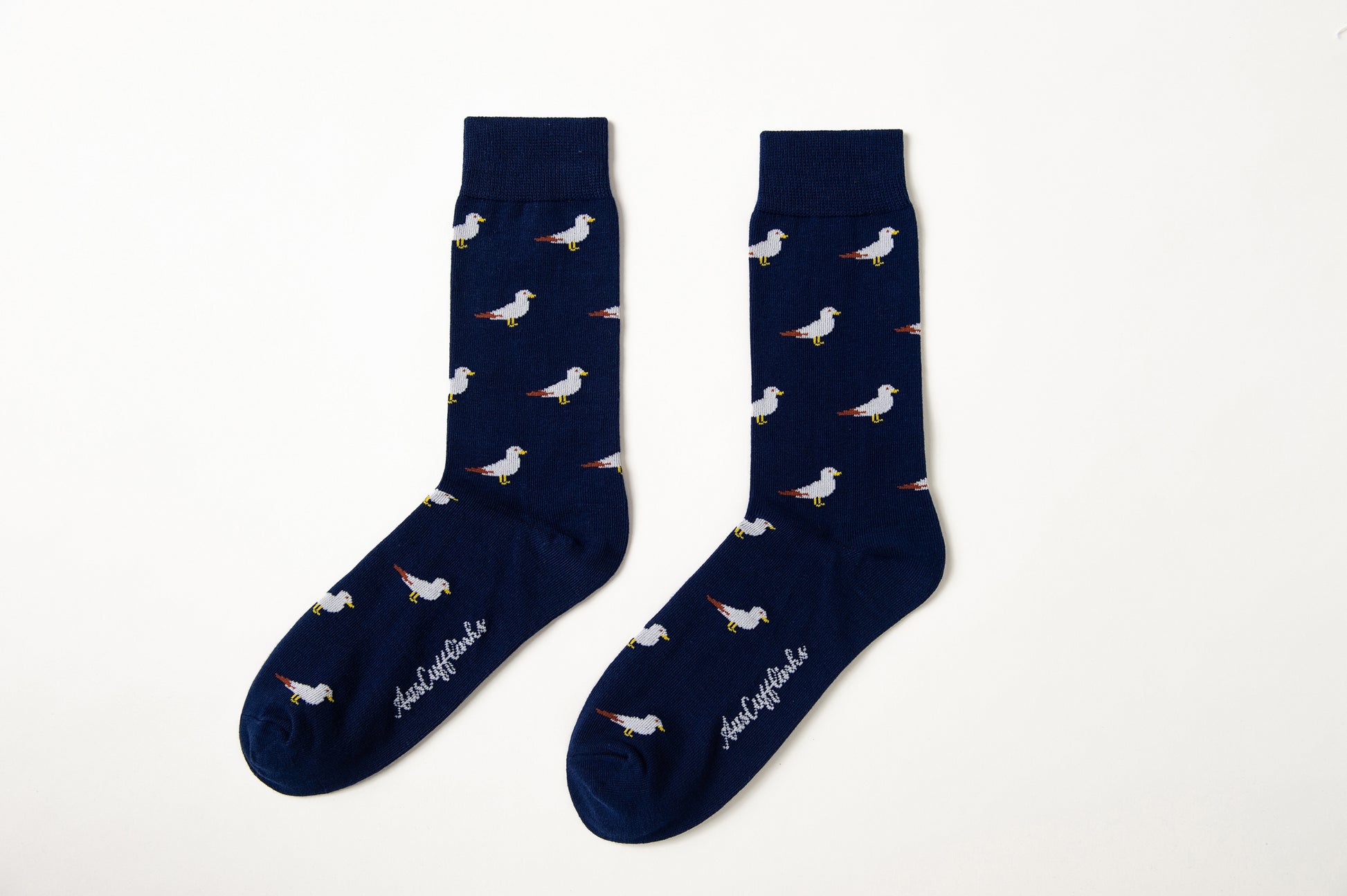 Fun novelty bird socks for men featuring flying seagull design on navy background