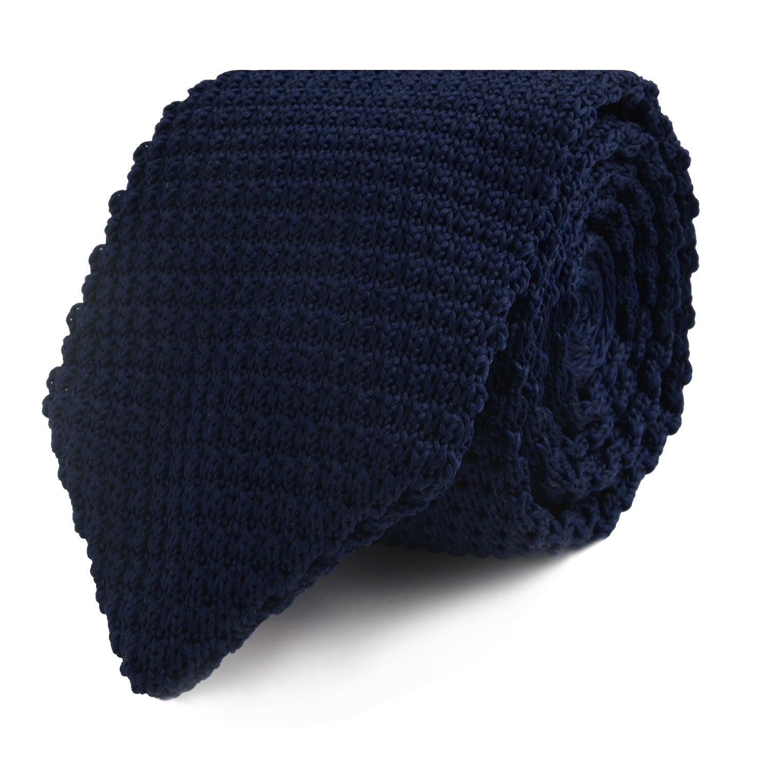 A rolled-up Navy Knitted Skinny Tie, showcasing its intricate weave, displayed against a white background.