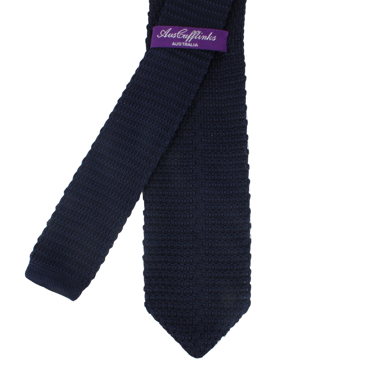 A Navy Knitted Skinny Tie with a purple tag labeled "AusCufflinks Australia" exudes an air of elegance, reminiscent of the deep-sea.