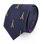 The Eiffel Tower Skinny Tie, featuring a navy blue base adorned with yellow and red Eiffel Tower patterns, woven to perfection and exuding Parisian elegance, is rolled up and displayed against a white background.