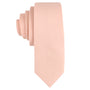 A neatly rolled, solid Baby Pink Skinny Tie, crafted with pastel threads, is depicted against a white background.