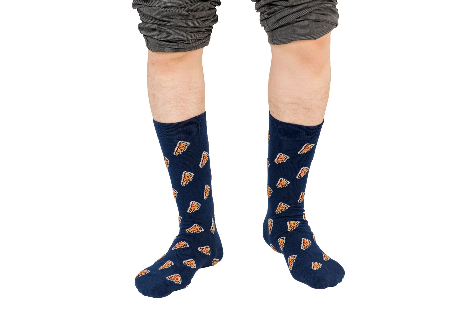 A person is stylishly wearing Pizza Socks with a vibrant pizza slice pattern, their pants comfortably rolled up to their knees.