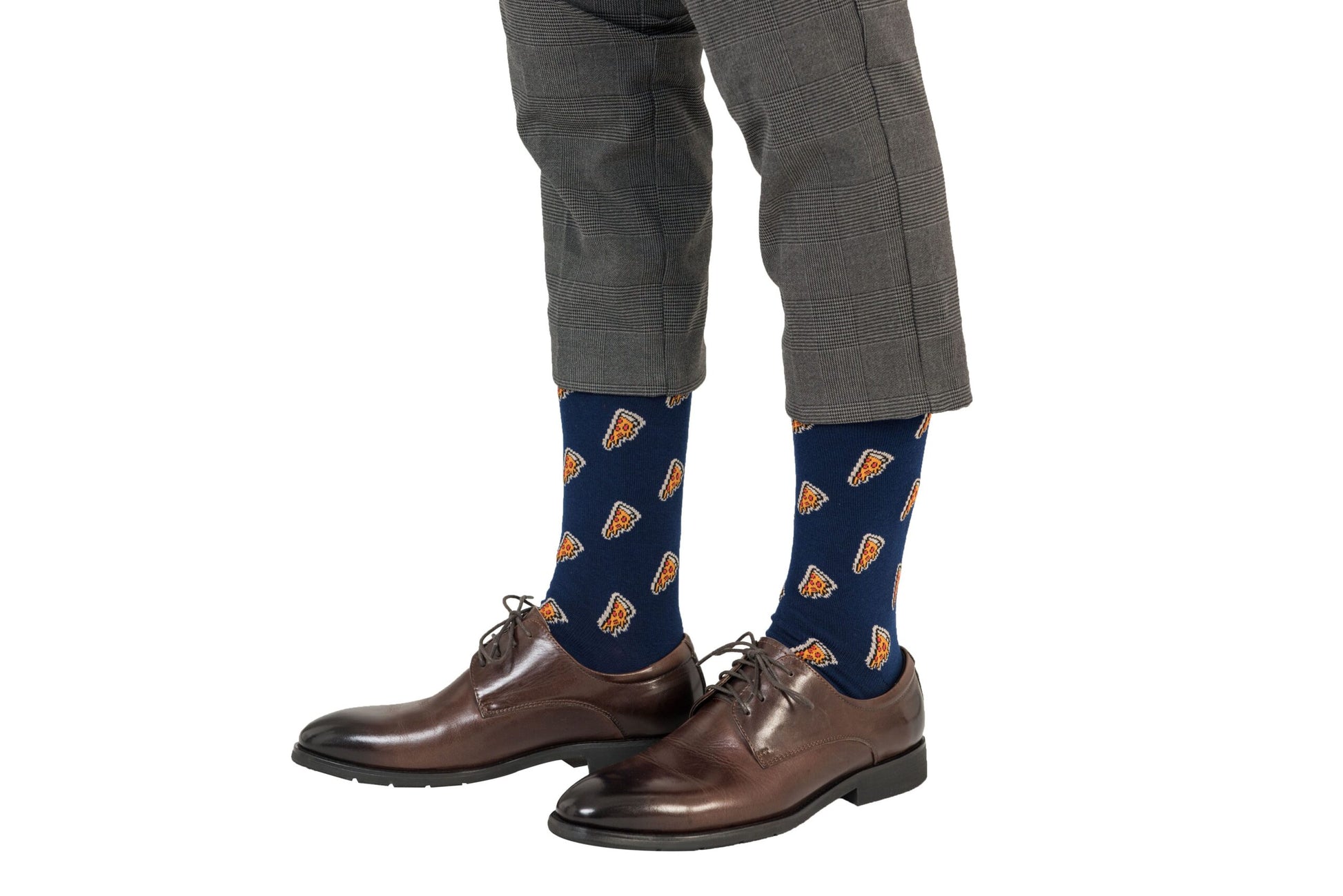 A person wearing gray checkered pants, Pizza Socks featuring playful pizza slice patterns in navy blue, and brown dress shoes balances comfort and style effortlessly.