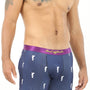 A man with tattooed arms models the Golf Swing Underwear, featuring dark blue boxer briefs with a purple waistband and white golfer prints, perfectly showcasing the ultimate drive for comfort.