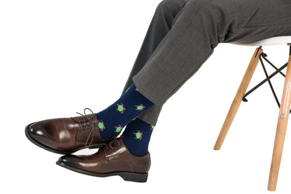 A man wearing a pair of Green Turtle socks is sitting on a chair.