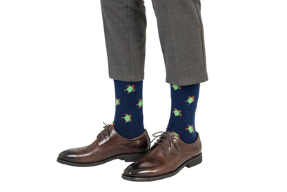 A man wearing a pair of brown pants and Green Turtle Socks.