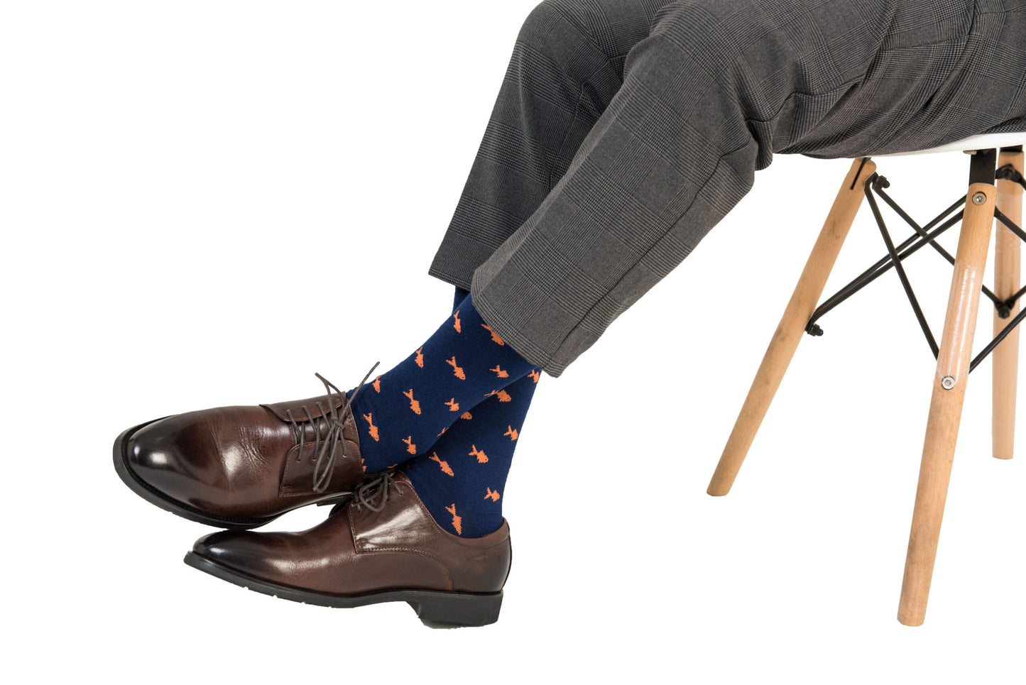 A person's legs and feet in brown shoes with Gold Fish Socks.