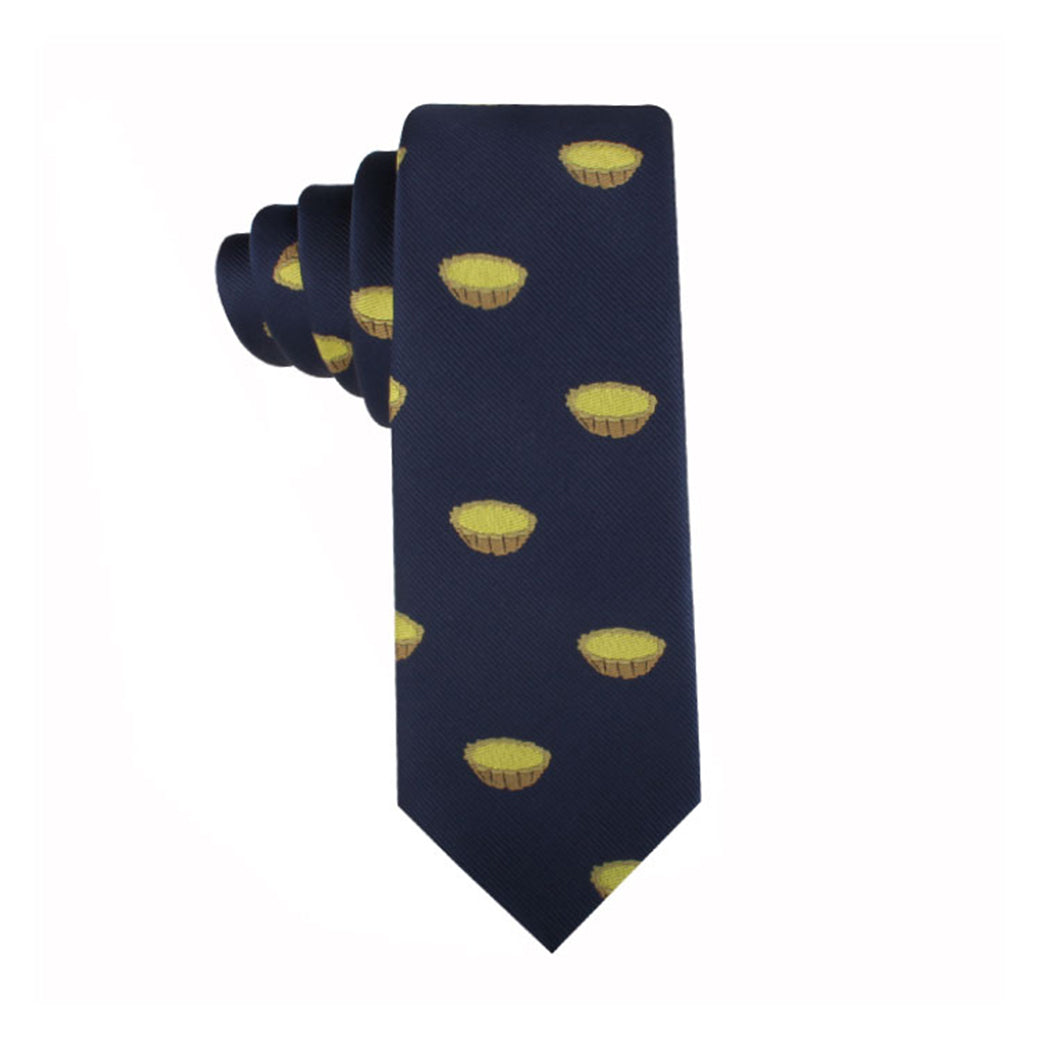 The Egg Tart Skinny Tie, in navy blue with a charming pattern of small yellow tart illustrations, is a unique addition to any fashion-forward wardrobe.