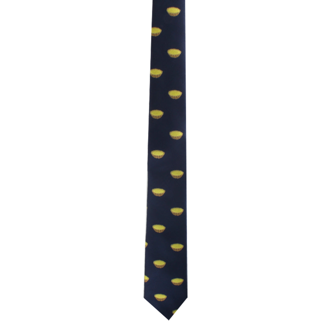 Presenting the Egg Tart Skinny Tie: a delightful dark blue necktie adorned with a repeating pattern of small yellow lemons, perfect for adding charm to any fashion ensemble.