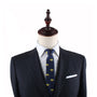 A mannequin dressed in a dark suit, white shirt, and the Egg Tart Skinny Tie with yellow patterns stands as a delightful testament to sophisticated fashion.