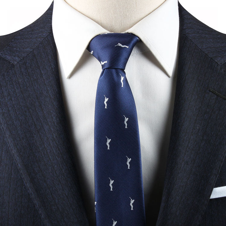 Close-up of a person wearing a white shirt, a dark pinstripe suit, and a Golf Swing Skinny Tie with small, white geometric patterns featuring a subtle golf motif.