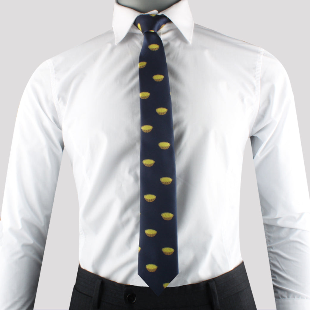 A person wearing a white dress shirt, an Egg Tart Skinny Tie with delightful yellow patterns, and dark trousers.