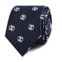 A rolled-up Soccer Skinny Tie featuring a pattern of embroidered white and black soccer balls, exuding timeless class and dynamic sportsmanship.