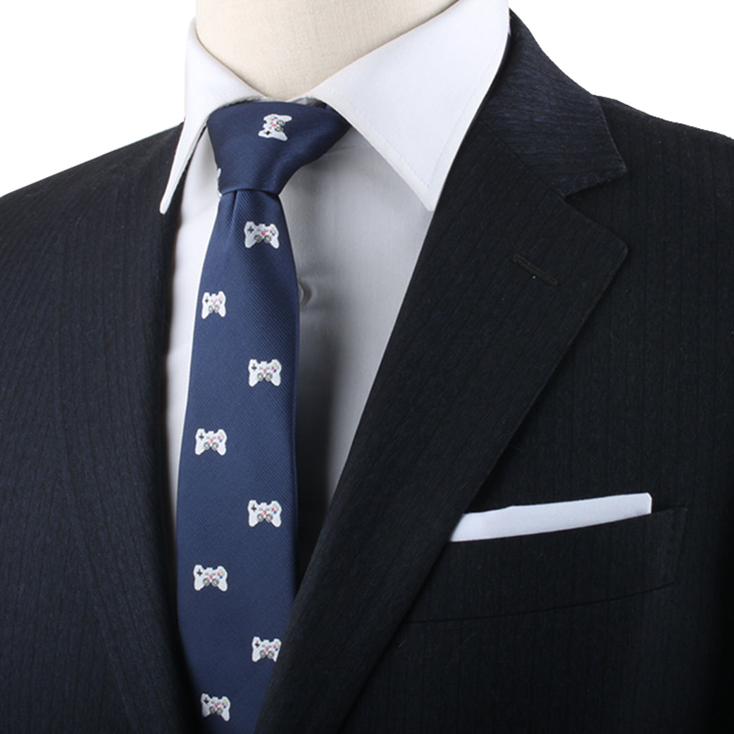 Mannequin dressed in a formal black suit, white dress shirt, and a blue Game Controller Skinny Tie—a look that effortlessly merges cutting-edge style for gamers and trendsetters alike. A white pocket square is neatly folded in the jacket's breast pocket.