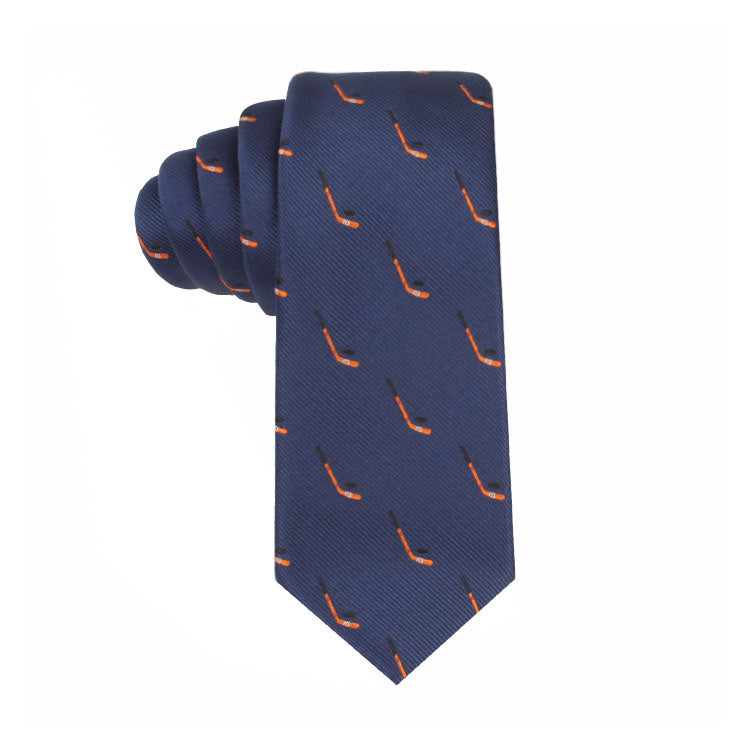 A navy blue Ice Hockey Skinny Tie with an orange and black pipe pattern, rolled up against a white background, exudes a timeless allure.