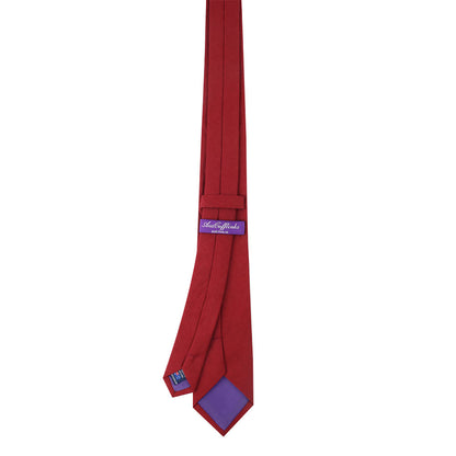 A Dark Red Business Cotton Tie with a purple inner lining and a purple tag displaying the brand name in white text, offering timeless style in a sophisticated product.