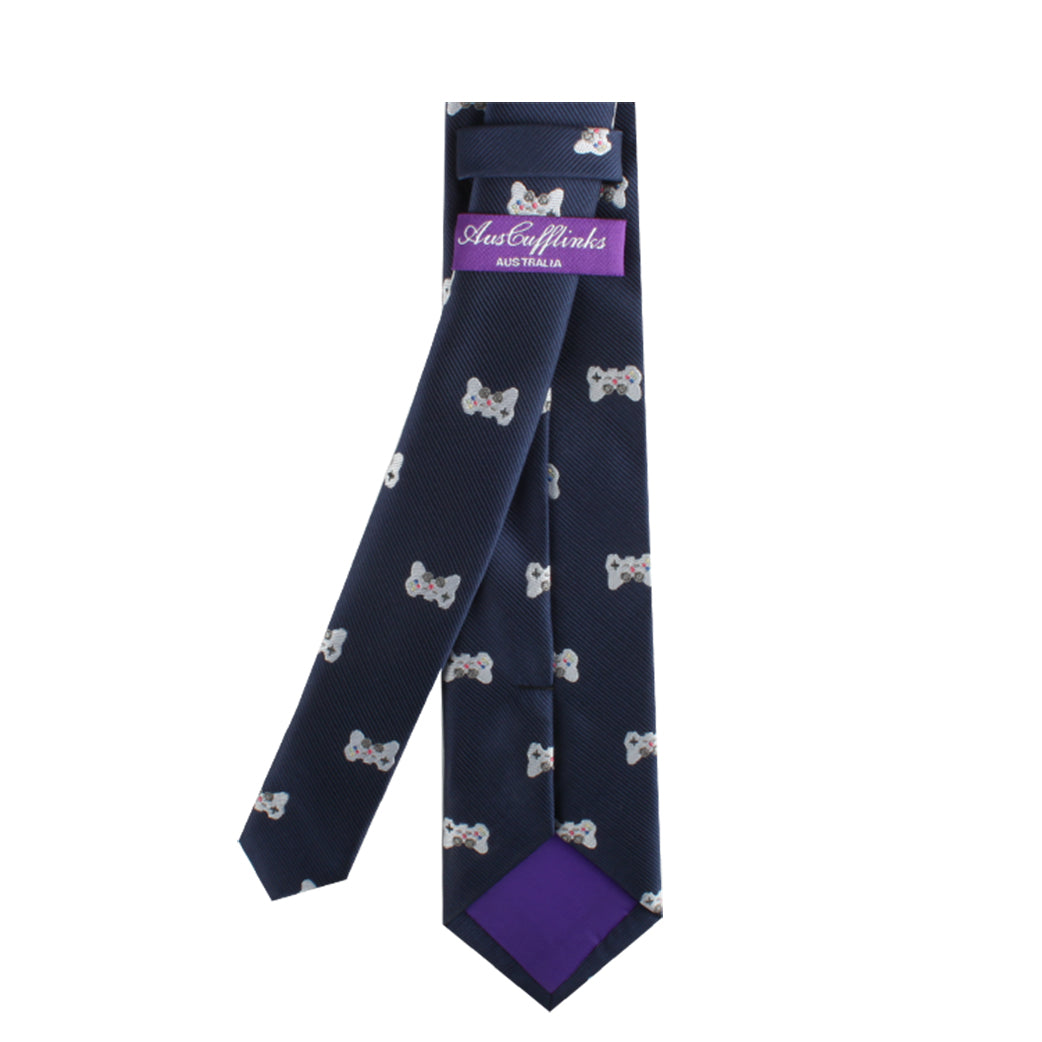 A dark blue necktie featuring a pattern of white and gray dog bones, complemented by a purple label from "Aussie Cufflinks" at the back, perfect for style-savvy trendsetters titled "Game Controller Skinny Tie".