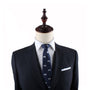 A dark grey suit with a white dress shirt and a Game Controller Skinny Tie is displayed on a mannequin with a wooden finial, perfectly capturing the style sought by trendsetters.