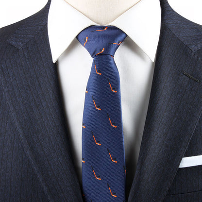 A man wears a dark pinstripe suit jacket, white dress shirt, and an Ice Hockey Skinny Tie adorned with a pattern of small orange pipes, showcasing a timeless allure.