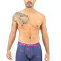 A man with tattoos standing in front of a cozy white background wearing Cyclist Underwear.