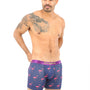 A bald man with a chest tattoo stands confidently in Pink Flamingo Underwear, isolated on a white background.