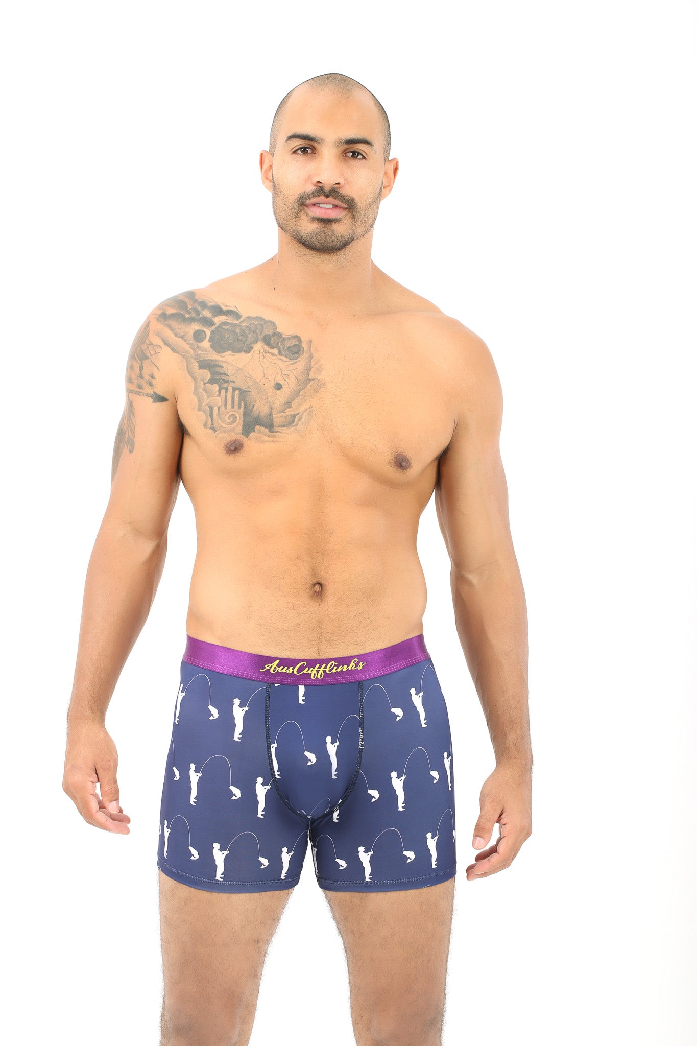 A man in Fisherman Underwear exudes comfort, showcasing a tattoo on his upper chest and arm as he stands confidently against a white background.