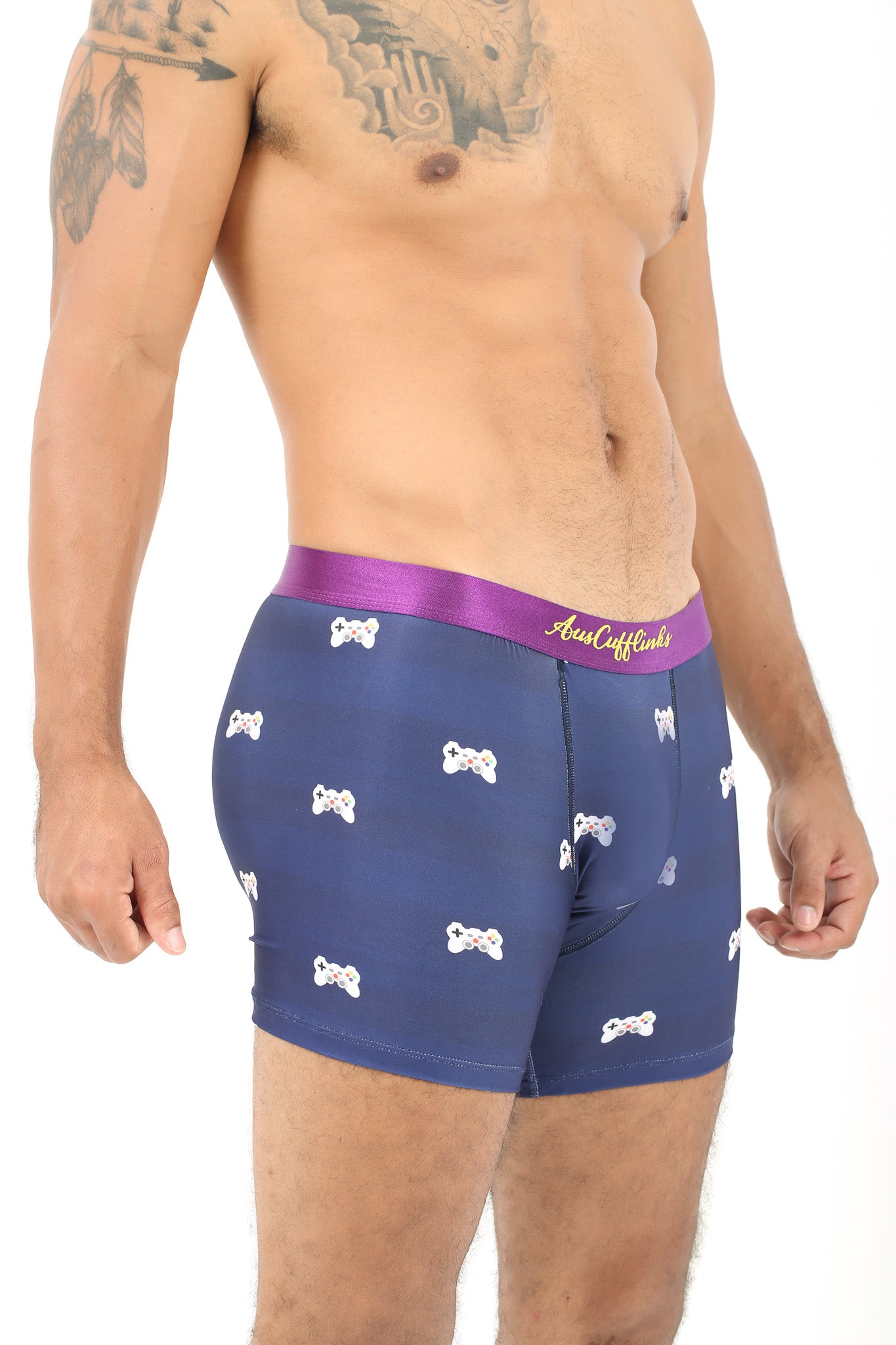 A man wearing the Game Controller Underwear, designed with navy blue fabric featuring bone patterns and a purple waistband, stands against a white background. His torso and upper thighs are visible, highlighting comfort that elevates your daily style.