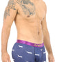 A shirtless man exudes style in Airplane Underwear featuring playful shark prints and a cozy purple waistband, reminiscent of vibrant skies.