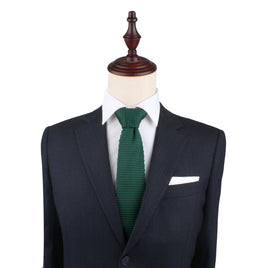 A tailored dark suit with a white dress shirt and a Green Knitted Skinny Tie, exuding elegance, displayed on a mannequin bust.