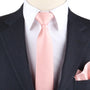 Close-up of a person exuding timeless elegance in a dark pinstripe suit, white dress shirt, and a Rose Gold Skinny Necktie, complemented by a matching pink pocket square. The look is completed with the subtle sheen of rose gold cufflinks.