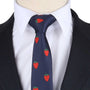 Close-up of a person wearing a dark suit with a white shirt and the Strawberry Skinny Necktie, adding a touch of fruity charm to the look.