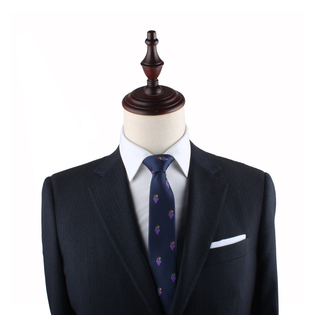 A mannequin exudes vineyard sophistication, wearing a dark suit with a white shirt and the Grapes Skinny Tie featuring a small pattern.