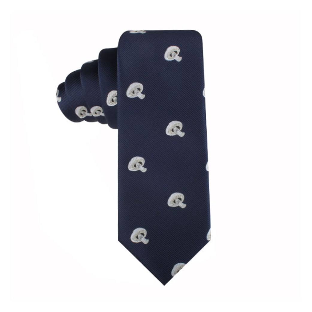 The Mushrooms Skinny Tie, featuring a repeating pattern of white paisley designs on a navy blue background, exudes elegance as it is rolled up at one end and displayed against a white backdrop.