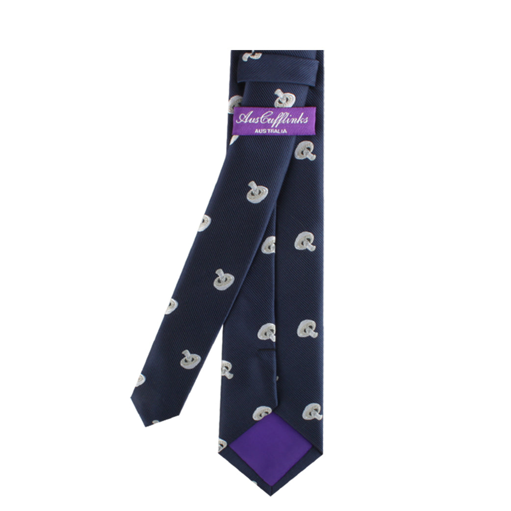 The Mushrooms Skinny Tie is a dark blue accessory adorned with a subtle, nature-inspired pattern of light blue and white elements, and features an inner purple label that adds a touch of elegance.