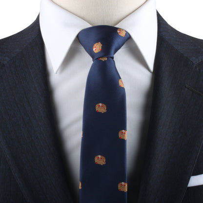 Navy blue Pancakes Skinny Tie with emblem patterns on a mannequin dressed in a white shirt and suit jacket.