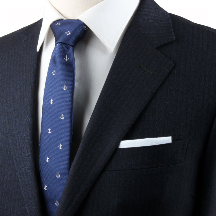 A mannequin wearing a navy suit with an Anchor Skinny Tie, exuding stability.