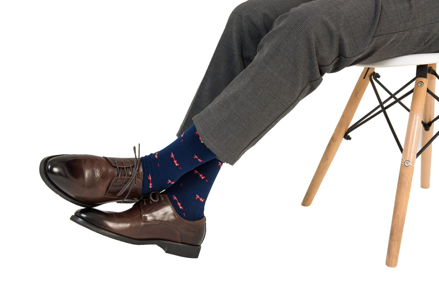 A man sitting on a chair showcasing his impressive sock game with a pair of Racing Car Socks.