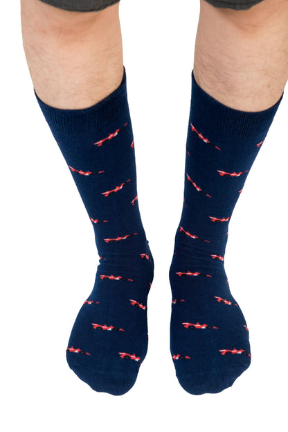 The legs of a man wearing Racing Car Socks with accelerate red birds on them.
