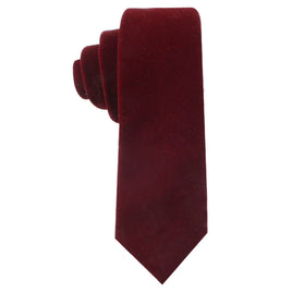 A rolled-up Maroon Velvet Skinny Tie with a tapered end exudes elegance, showcasing plush, rich tones.