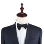 A classic Black Cotton Self Tie Bow Tie on a mannequin dummy.