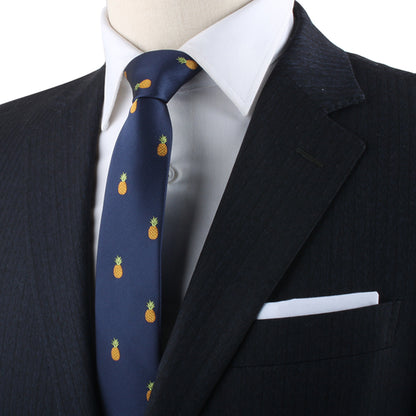 A close-up of a person in a dark suit, white shirt, and a Pineapple Skinny Tie exudes tropical allure and modern elegance.