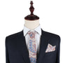 A mannequin exuding charm in a dark suit with a white dress shirt is accessorized with the Blue Latte Brown Paisley Skinny Necktie and matching Pocket Square Set.