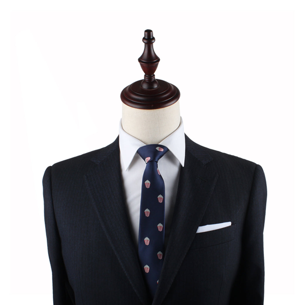 A cinematic dark suit jacket with a white dress shirt and a Popcorn Skinny Tie, displayed on a headless mannequin with a wooden stand, making a strong style statement.