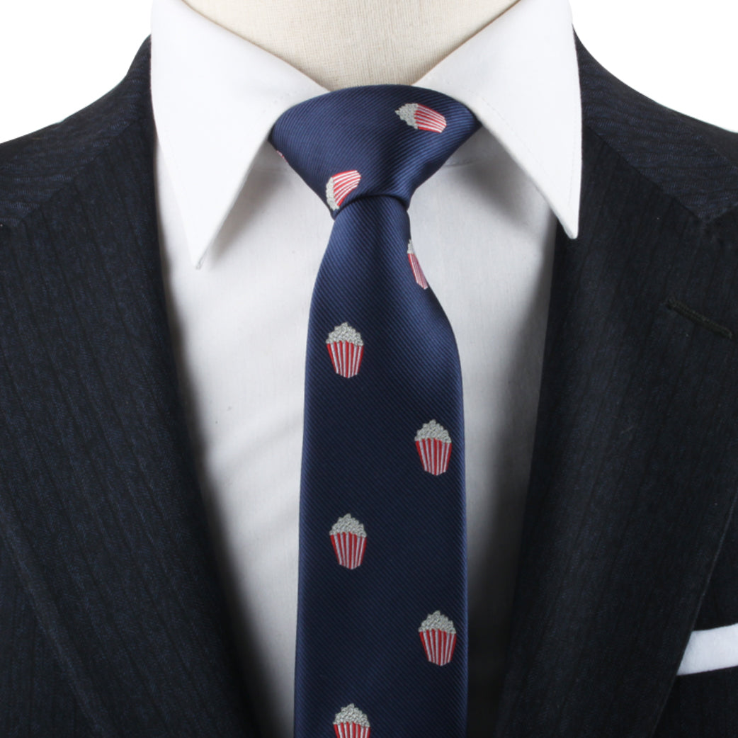 A close-up of a person wearing a dark pinstripe suit and a white dress shirt, with a Popcorn Skinny Tie—a true cinematic statement of style.