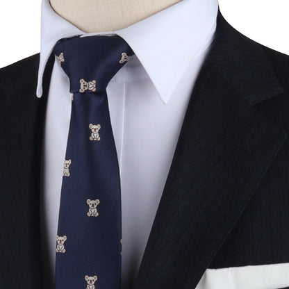 Close-up of a person wearing a navy blue Koala Skinny Tie, a white dress shirt, and a dark pinstripe suit jacket.