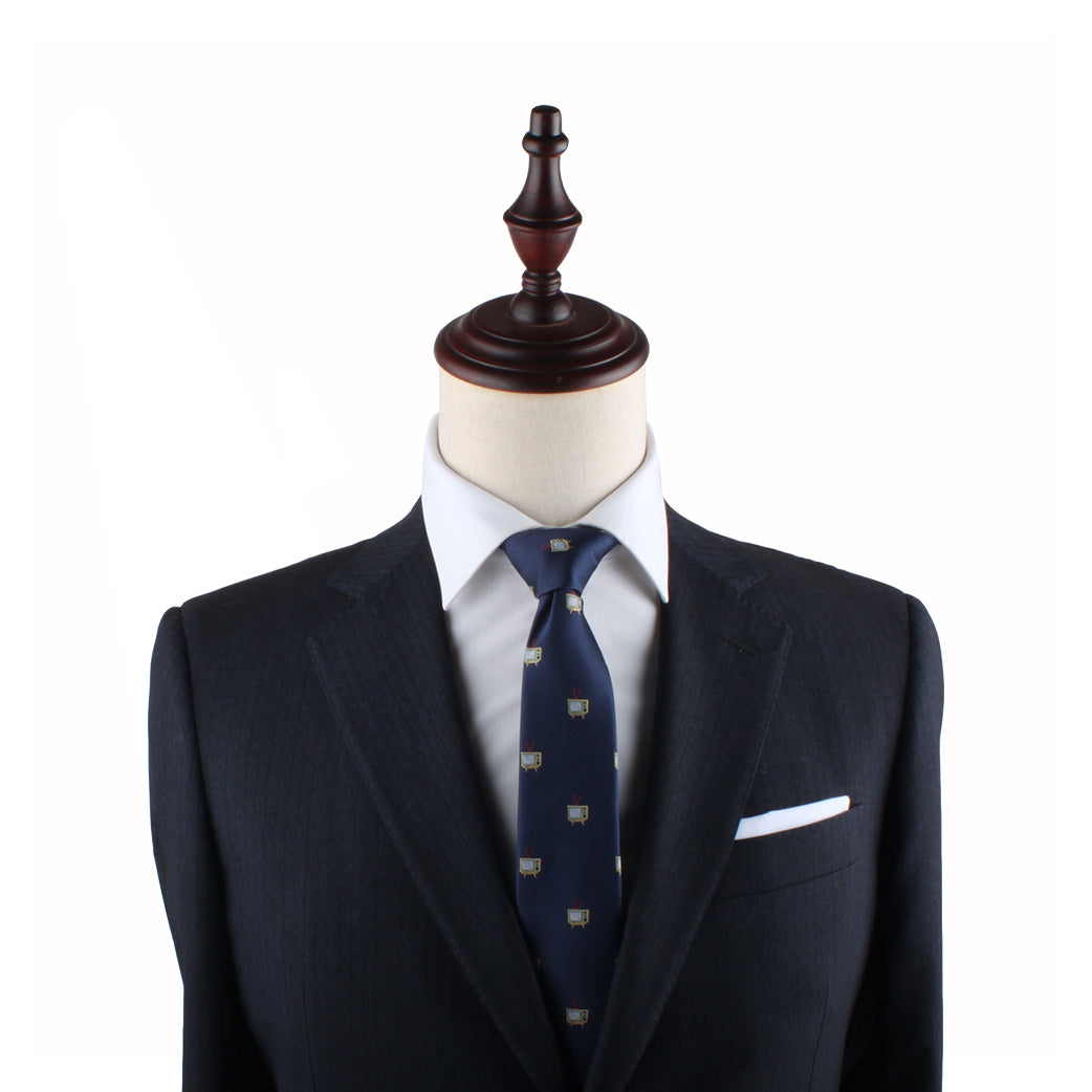 A mannequin dressed in a dark suit with a white shirt and the TV Skinny Tie, accessorized with a white pocket square, exudes an air of elegance perfect for any entertainment event.